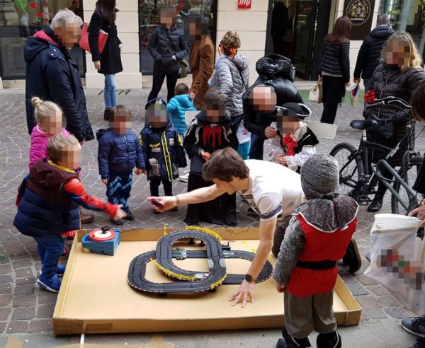 un gruppo di bambini accompagnati dai genitori si diverte con i giochi primaverili organizzati da Incisoria Vicentina fuori dal negozio